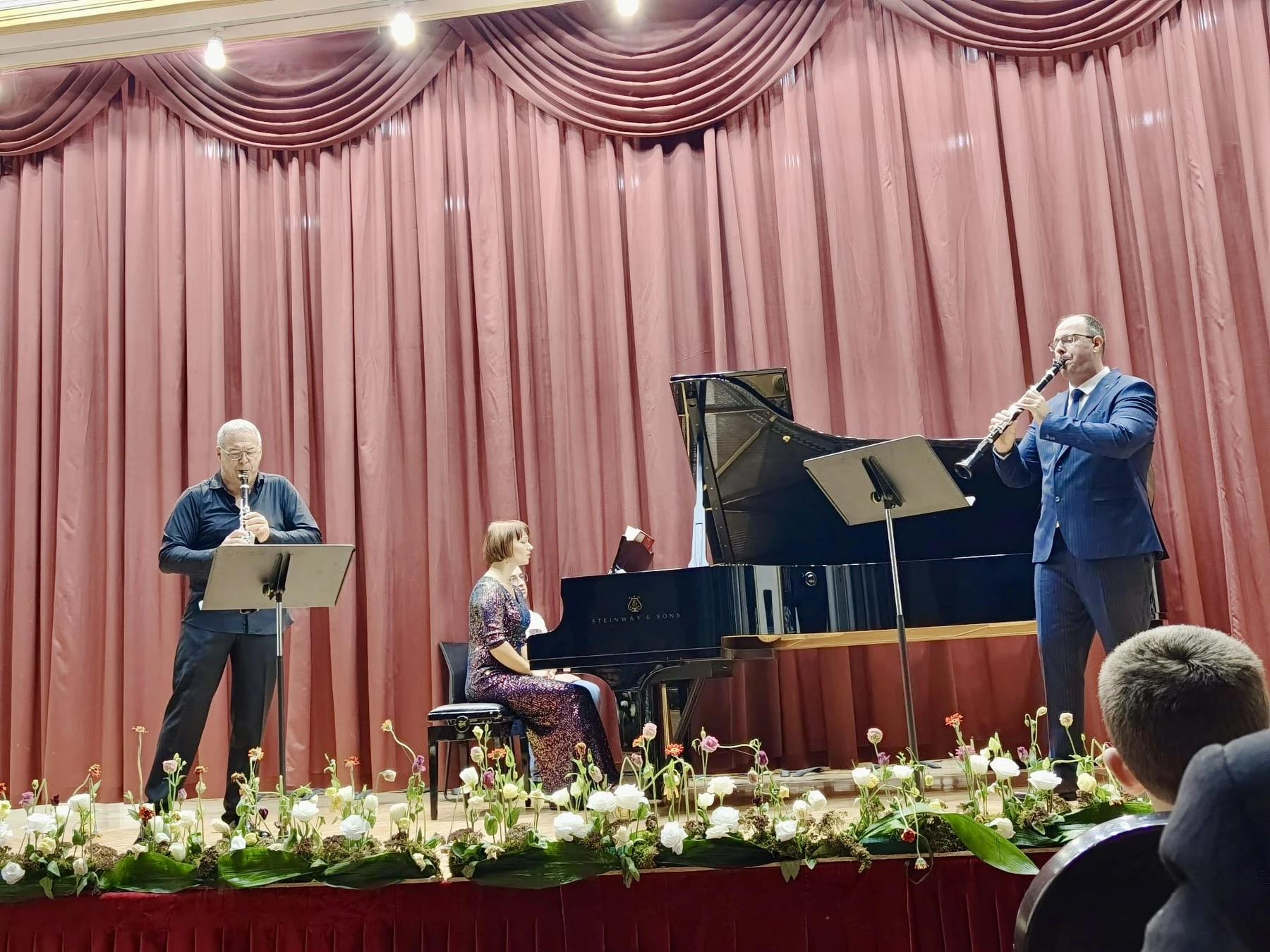 Clarinet recital with piano on a red-curtained concert stage